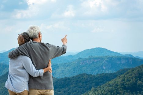 mature couple viewing beautiful mountains with arms around each other