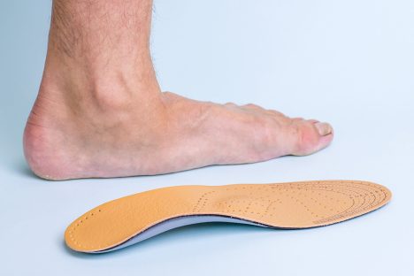 foot on the floor next to a foot orthotic