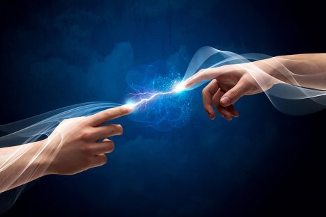 Small electrical exchange between two hands reaching towards each other