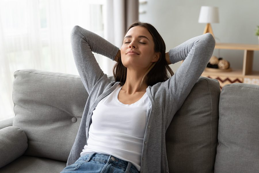 smiling woman relaxing on couch at home